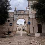 Per accedere alla corte in cui si trova il santuario oltrepassiamo un arco in pietra decorato da un bassorilievo della Vergine